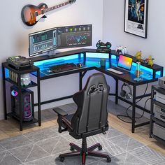 a computer desk with two monitors and a guitar on the wall behind it, along with other electronic equipment