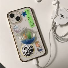 an iphone case with some stickers on it and earphones attached to the back