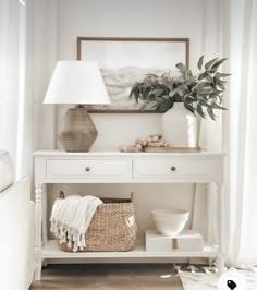 a white table with a basket and lamp on it