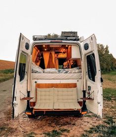 an rv parked on the side of a road with its doors open and mattresses in the back