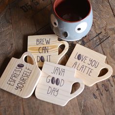 four wooden coasters with words on them and a cup of coffee in the middle