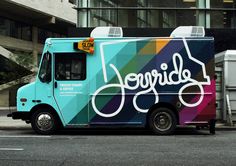 an ice cream truck parked on the side of the road in front of a building