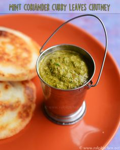 some food is sitting on a plate with a small metal cup and sauce in it