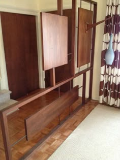 an empty room with wooden furniture and curtains