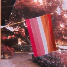 a red, white and orange flag hanging from a pole