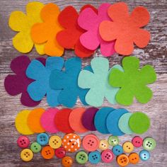 colorful felt flowers and buttons laid out on a wooden surface