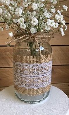 a mason jar filled with white flowers on top of a table