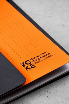 an orange and black notebook sitting on top of a table