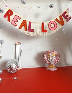 there is a red table with decorations on it and a sign that says real love