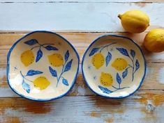 two bowls with lemons in them on a wooden table