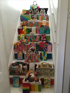 there are many bags and purses on the stair case that is decorated with ribbons