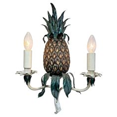 a pineapple chandelier with two candles on each arm and one candle in the center