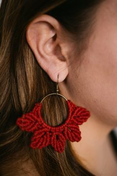 a woman wearing large red crochet earrings with gold hoop and circular drop earring