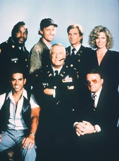 a group of men and women in uniform posing for a photo with one man wearing glasses