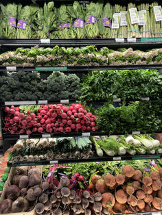 an assortment of vegetables on display in a grocery store, including radishes and lettuce