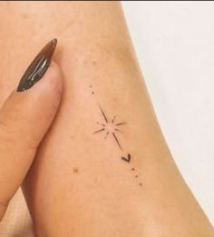 a woman's arm with a small star tattoo on it and her left foot