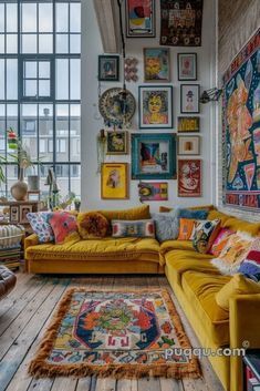 a living room filled with lots of furniture and pictures on the wall above it's windows