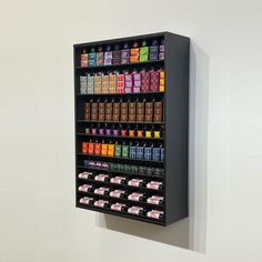 a wall mounted display case filled with lots of different colored drinks and condiments