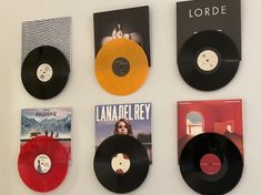 four different colored vinyl records are on the wall