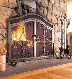 a fire place sitting on top of a wooden floor next to a stone wall and potted plant