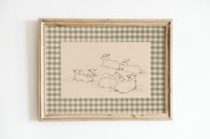 a painting hanging on the wall with sheep in it's frame and another drawing behind it