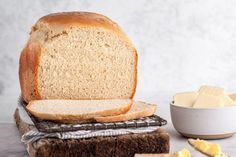 a loaf of bread sitting on top of a table next to sliced cheese and butter