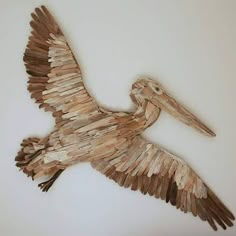 a bird made out of wood sitting on top of a wall