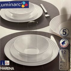 two white dinner plates sitting next to each other on top of a black place mat