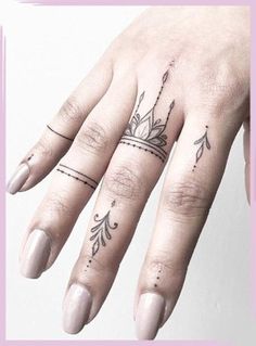 a woman's hand with tattoos on it and a crown tattooed on the middle finger