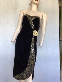 "Vtg 80s strapless Dave & Johnny black velvet cocktail formal dress with gold edging and flower. Preowned. Condition 10/10 Style Pencil style black velvet cocktail party formal dress with gold detailing on the wrap over style border and a large gold self fabric flower at the waist. Boned bodice.  Fully lined Sassy, hourglass look  dark rich velvet.  Label. Dave & Johnny Labelled S  Go by measurements below.  Garment laid flat  Underarm to underarm. 17.5\". 44.5cm Waist. 13.5\".  34cm Hips. 20\".  50.5cm Length from underarm. 32.5\". 82.5cm My photos form an important part of the product description so please look at them and ask questions. I want you to purchase with confidence. Posted within 24 hours of receiving your payment. Thanks for looking. If you are a devotee of vintage and yester Cocktail Formal Dress, Party Formal Dress, Black Velvet Cocktail, Cocktail Formal, Boned Bodice, 80s Dress, Fabric Flower, Mode Vintage, Cocktail Dress Party