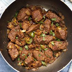 meat and vegetables cooking in a pan on the stove