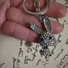 a person holding a keychain with a rabbit on it