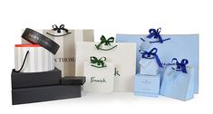 several gift bags with ribbons and tags on them