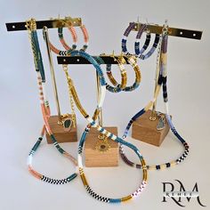 several bracelets and necklaces hanging from hooks