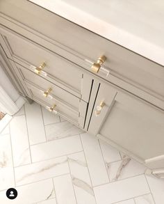 an overhead view of a white kitchen with gold hardware