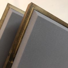 a close up of a framed object on a white surface with gold trimmings