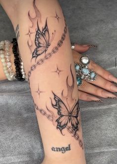 a woman's arm with a butterfly tattoo on it and the word angel written in black ink