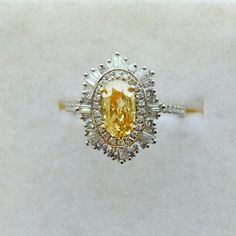 a fancy ring with an oval cut yellow diamond surrounded by smaller round diamonds on each side