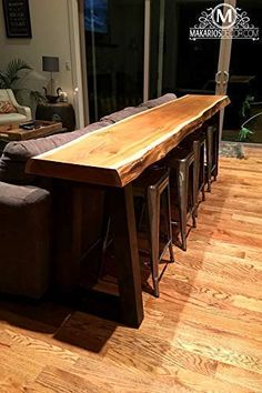 a large wooden table sitting in the middle of a living room next to a couch