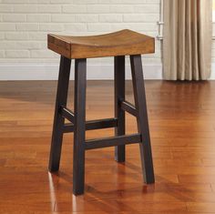 a wooden stool sitting on top of a hard wood floor