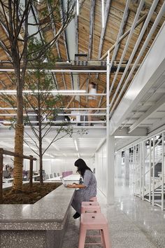 a woman sitting at a table with a laptop on top of it next to a tree