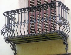 a balcony with iron railings and decorative decorations on the balconies above it