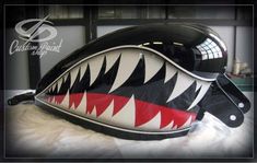 the helmet is designed to look like a shark's mouth with red, white and black teeth