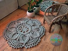 two crocheted rugs sitting on the floor next to a chair and potted plant