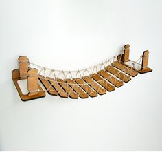 there is a miniature wooden bridge made out of wood and rope with chairs attached to it