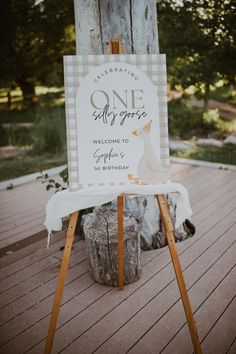 a sign that is on top of a wooden easel in front of a tree