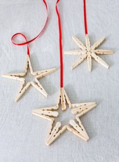 three wooden star ornaments hanging from red string