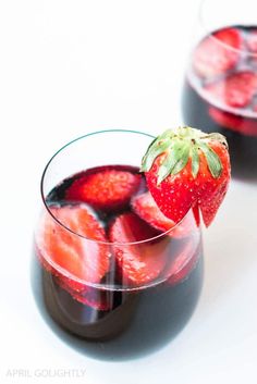 two glasses filled with liquid and strawberries