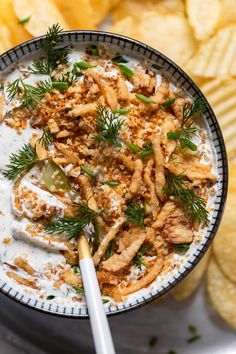 a bowl filled with food next to chips