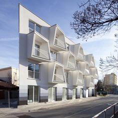 an apartment building with white balconies on the side